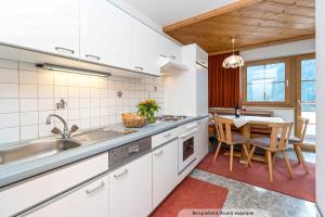 a kitchen with a sink and a table with chairs at Apart Christine in Kappl