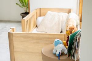 a crib with stuffed animals sitting in it with a bed at Villa Aura Lombok in Selong Belanak