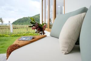 a couch with a blanket on it with a window at Villa Aura Lombok in Selong Belanak