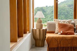 a living room with a chair and a lamp and a window at Villa Aura Lombok in Selong Belanak