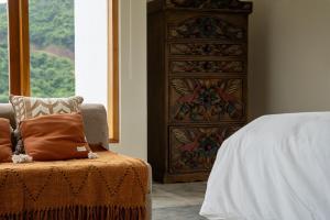 a bedroom with a dresser and a chair next to a bed at Villa Aura Lombok in Selong Belanak