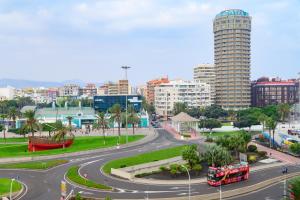 a street in a city with a double decker bus at La Marquesa Ten Suites Canteras in Las Palmas de Gran Canaria
