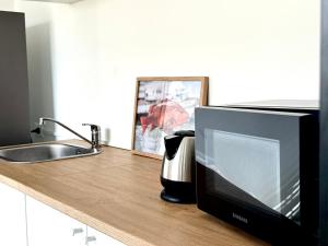 a kitchen counter with a television and a sink at Thapmu-homie in Ban Lam Ru (1)