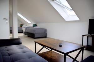 a living room with a couch and a bed and a skylight at Appartementhaus in Altlandsberg