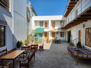 an outdoor patio with wooden tables and chairs at Samani Bukhara in Bukhara