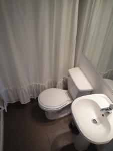 a bathroom with a white toilet and a sink at The Travelling Chile in Valparaíso