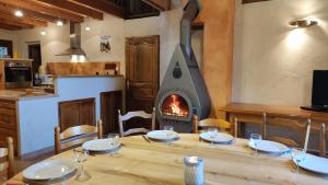 a dining table with a wood stove in a kitchen at Chalet Mounette Ski Sauna Lac Embrun in Puy-Sanières