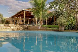 a house with a swimming pool in front of a house at Espaço 27 - vista para a Serra de Caldas in Caldas Novas