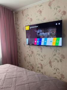a flat screen tv hanging on a wall at Apartment on Bukhar Zhyrau in Karagandy