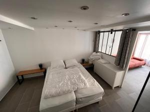 a bedroom with a bed and a couch and a window at Appartement cœur de village 1-8 pers in Barèges