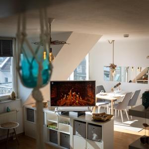 a living room with a flat screen tv on a entertainment center at Lake Breeze Maisonette in Leipzig, Balkon und See in Markkleeberg