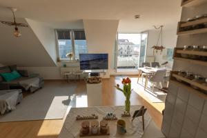 a large living room with a couch and a tv at Lake Breeze Maisonette bei Leipzig in Markkleeberg