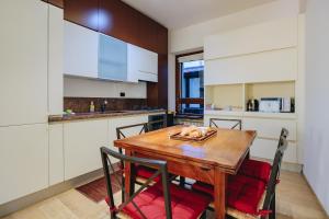 Una cocina con una mesa y sillas de madera. en SG Luxury - My Harbour Stay, en Peschiera del Garda