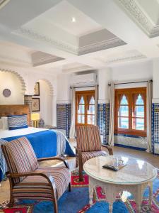 RIAD TANJA by chef Moha في طنجة: غرفة نوم بها سرير وطاولة وكراسي