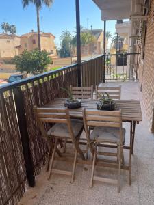 a wooden table and chairs on a balcony at Apartamento Neptuno A4 in Puebla de Farnals