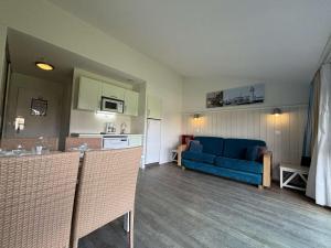 Il comprend une cuisine et un salon avec un canapé bleu. dans l'établissement Appt 2 pièces ILE DE RE - SAINT MARTIN DE RE - IDR400-062, à Saint-Martin-de-Ré