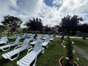 une rangée de chaises de jardin blanches assises dans l'herbe dans l'établissement Appt 2 pièces ILE DE RE - SAINT MARTIN DE RE - IDR400-062, à Saint-Martin-de-Ré