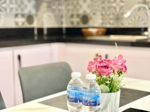 two bottles of water sitting on a table with flowers at SKY HOTEL Central Phnom Penh - Rooms & Apartments in Phnom Penh +71 photos