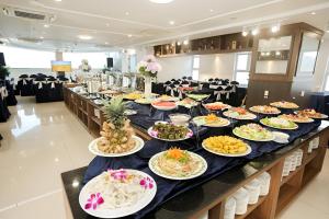 een lange tafel met borden met eten erop bij Luxury Condotel - Mermaid Seaside Hotel Vung Tau in Vung Tau