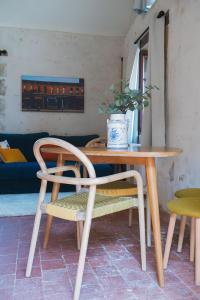 a wooden table and a chair and a table and chairs at Gîte Sidonie in Apremont