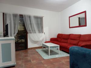 a living room with a red couch and a table at Eserò in Tamaduste