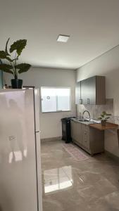 a kitchen with a sink and a refrigerator at Apartamento completo e bem localizado in Sinop