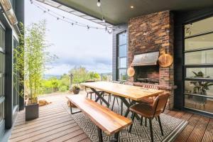 a patio with a wooden table and chairs and a brick wall at Charming 6-Bed Escape- Balconies & Panoramic Views in Golden Ball