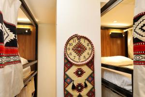 a clock on a wall in a room at Sands Inn Hostel - City Center in Riyadh