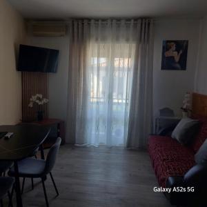 a living room with a red couch and a window at NATALI Appartamens Rosa in Malcesine