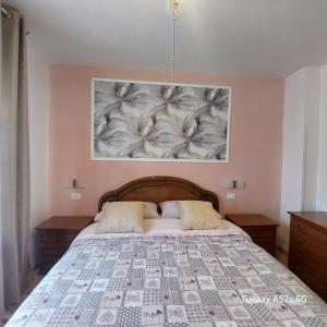 a bedroom with a bed with a flower painting on the wall at NATALI Appartamens Rosa in Malcesine