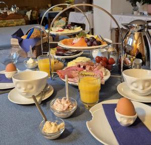 a table with plates of food and eggs on it at Ostsee Pension Pohnsdorfer Mühle in Sierksdorf