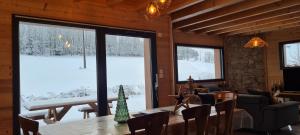 AnouldCHALET L'ÉCHAPPÉE NATURE 4 étoiles sauna的带桌子和大窗户的餐厅