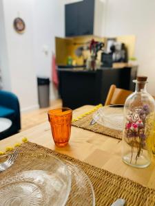 a wooden table with plates and a vase with flowers in it at L'Arôme - Studio intimiste à deux pas du tram et des facultés in Talence