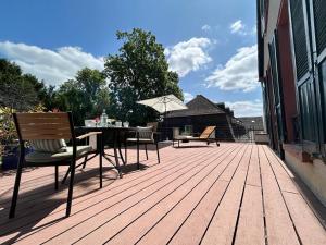 eine Holzterrasse mit Tisch, Stühlen und Sonnenschirm in der Unterkunft Hotel Tillmanns in Eltville + 24 Fotos