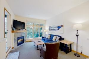 a living room with a blue couch and a fireplace at Northstar 71 in Whistler