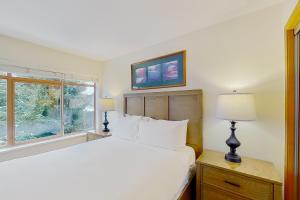 a bedroom with a white bed and a window at Northstar at Stoney Creek in Whistler +12 photos