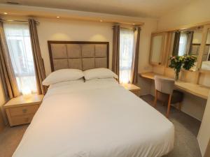 a bedroom with a large white bed with two pillows at Lodge 3 in Carnforth