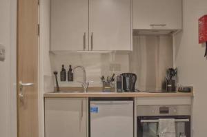 a kitchen with white cabinets and a sink at Redcross studio flat 312 in Bristol