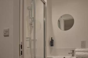 a bathroom with a shower and a mirror and a sink at Redcross studio flat 312 in Bristol