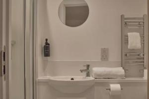 a white bathroom with a sink and a mirror at Redcross studio flat 312 in Bristol