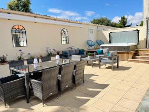eine Terrasse mit einem Tisch, Stühlen und einem Klavier in der Unterkunft Le Rivage, maison proche mer avec Spa in Les Sables-dʼOlonne