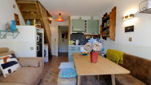 a living room with a table and a kitchen at L'ENVOLéE in Samoëns