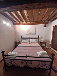 duże łóżko w pokoju z drewnianym sufitem w obiekcie Casa Costanza w mieście Castiglione dʼOrcia
