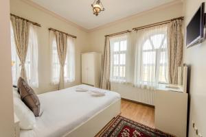 a bedroom with a bed and two windows at Akuzun Stone Hotel in Ürgüp +74 photos