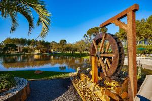 a water wheel in front of a pond at Hospedaria Morada das Grimpas in Palmeira