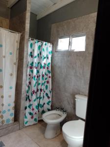 a bathroom with a toilet and a shower curtain at Complejo Conejo in San Antonio de Areco