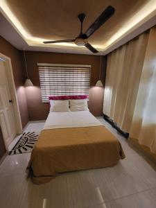a bedroom with a bed and a ceiling fan at Accra Apartments in Accra