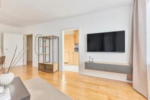 a living room with a flat screen tv on a wall at Mira - stillvolle Wohnung im Zentrum von Bretten in Bretten