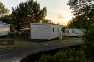 a small white building on the side of a road at Camping La Pointe du Médoc in Le Verdon-sur-Mer
