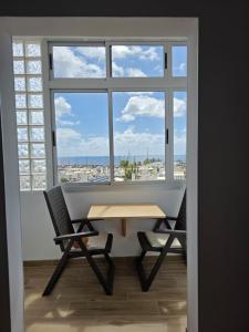 a table and chairs in a room with a large window at Casa Balcon 2 bedroom by El Sirocco in Puerto de Mogán